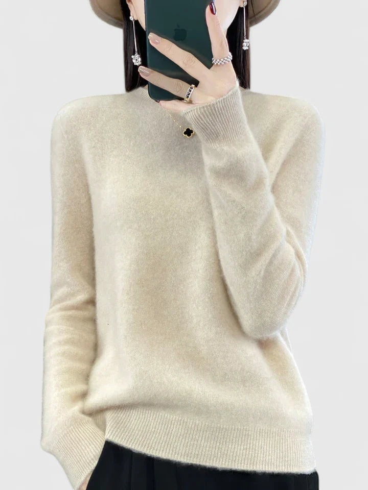 Jersey crema de cuello redondo y corte holgado, combinado con pantalón negro.