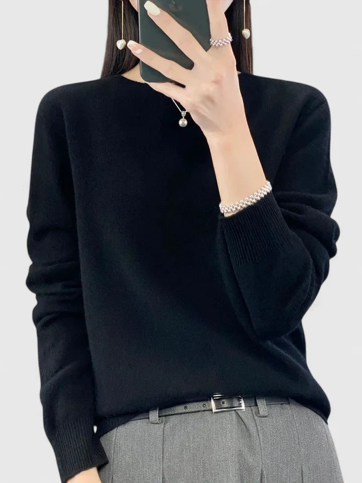 Jersey negro de corte relajado y cuello redondo, combinado con pantalón gris.