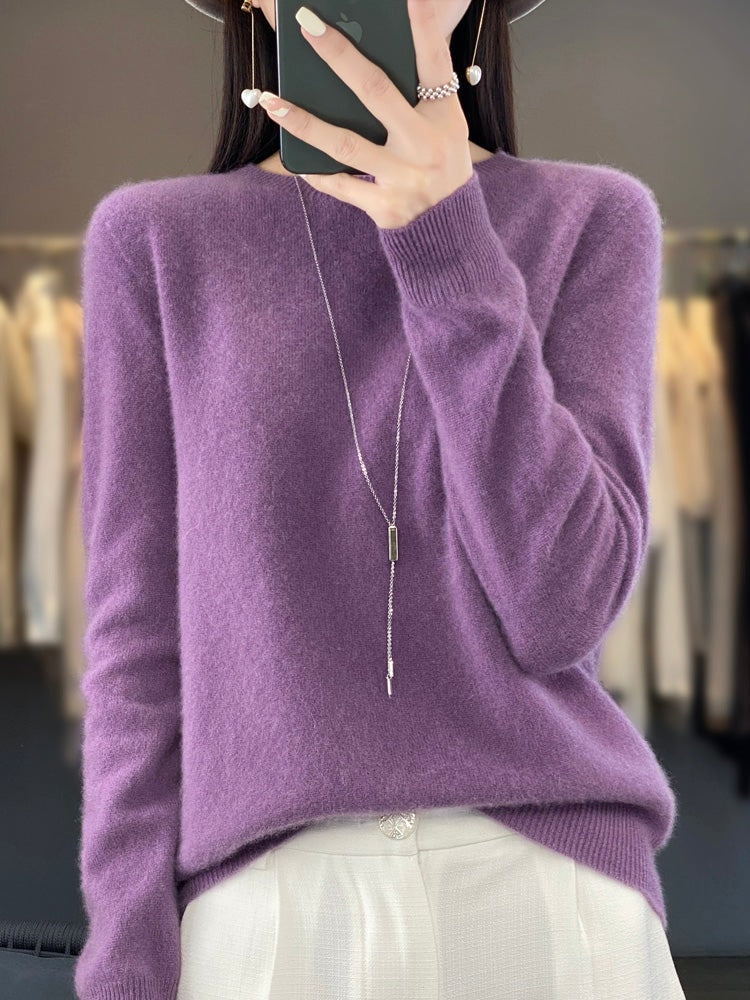 Jersey morado de corte relajado y cuello redondo, llevado con pantalón claro y collar largo.
