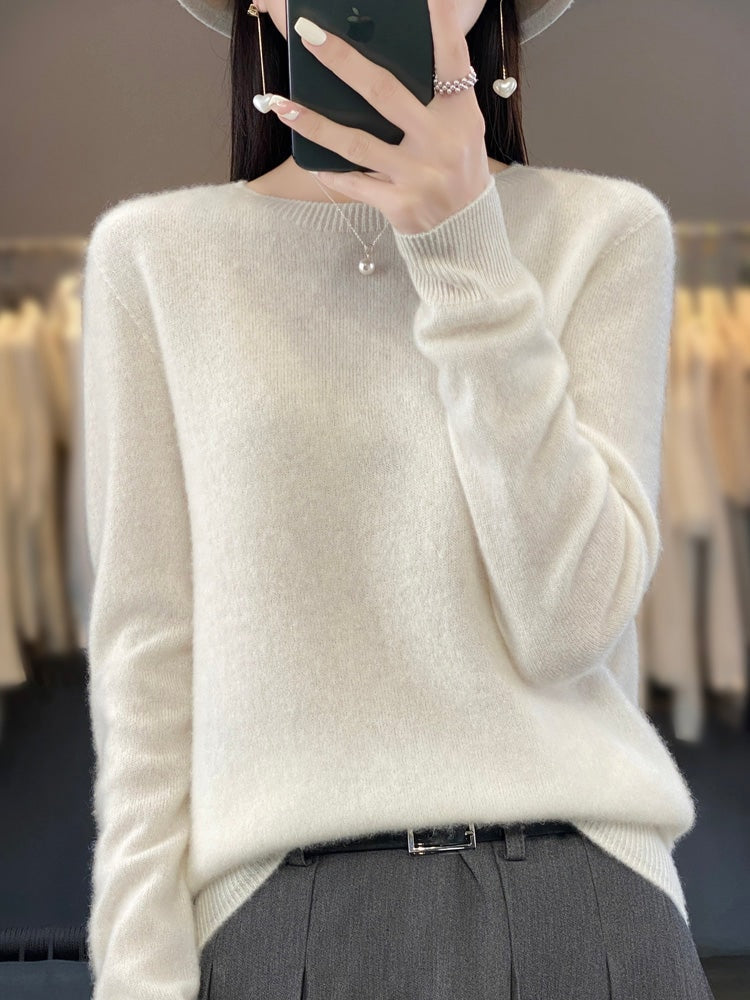 Jersey blanco marfil de cuello redondo, combinado con pantalón oscuro y cinturón.
