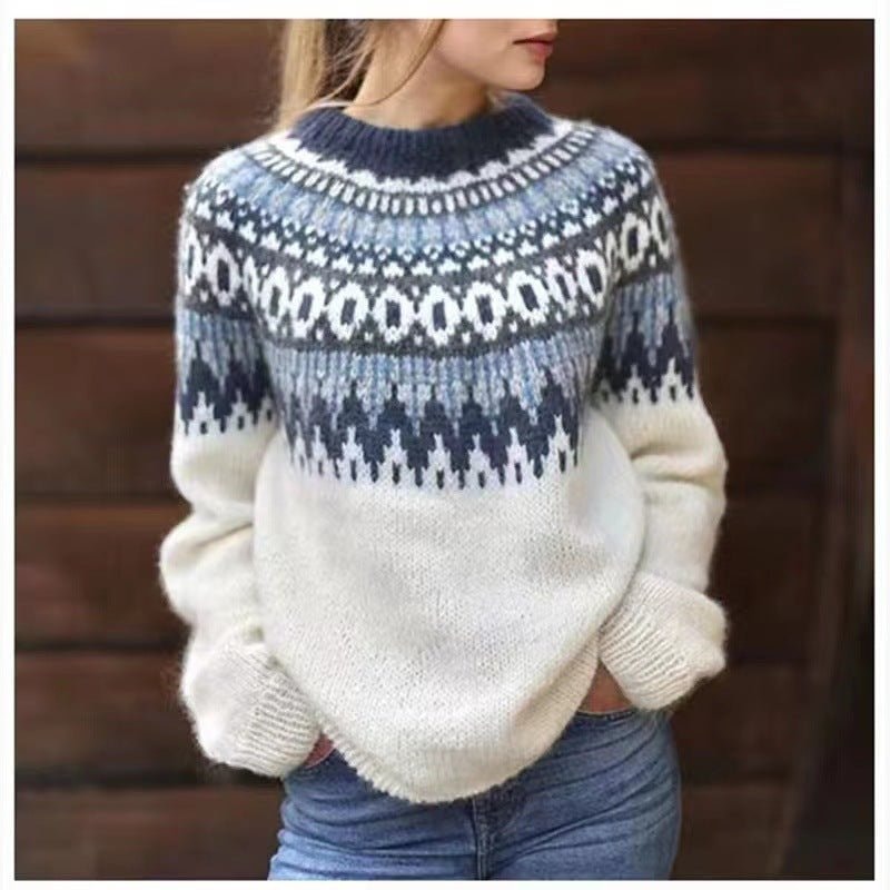 Jersey de invierno blanco con estampado nórdico azul alrededor del cuello y los hombros, combinado con vaqueros.