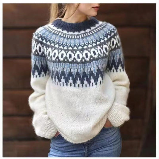 Jersey de invierno blanco con estampado nórdico azul alrededor del cuello y los hombros, combinado con vaqueros.
