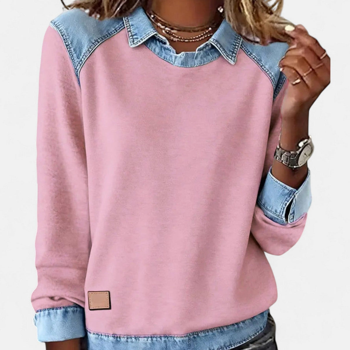 Jersey rosa de mujer con cuello camisero, hombros, puños y bajo en contraste azul claro, visto de frente.
