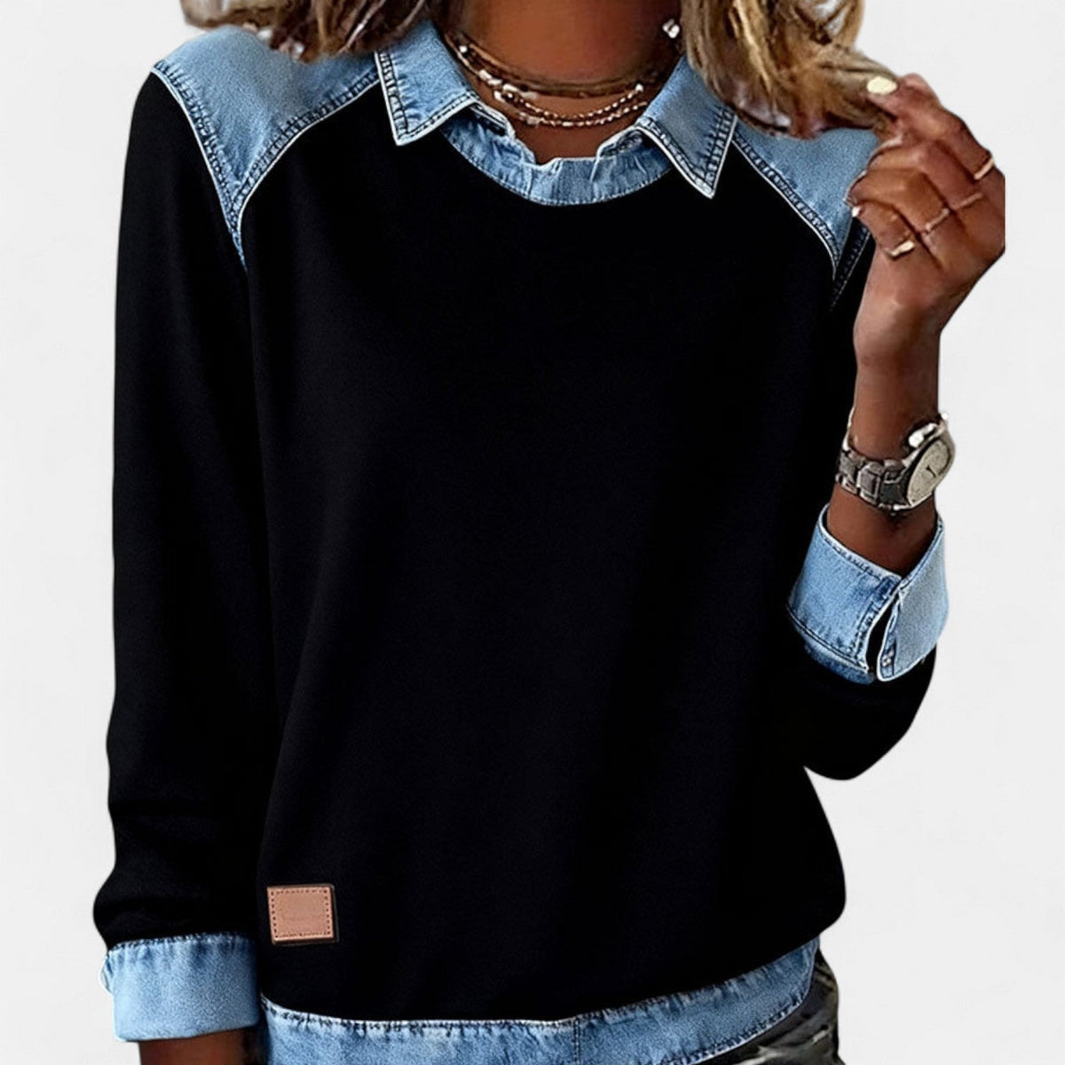 Jersey negro de mujer con cuello camisero, hombros, puños y bajo en contraste azul claro, visto de frente.