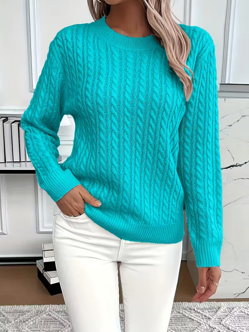 Jersey azul turquesa de punto calado con cuello redondo y mangas largas, combinado con pantalón blanco.