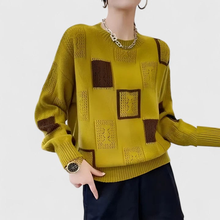 Jersey verde oliva de punto calado con rectángulos geométricos en tonos marrones, cuello redondo y puños acanalados.
