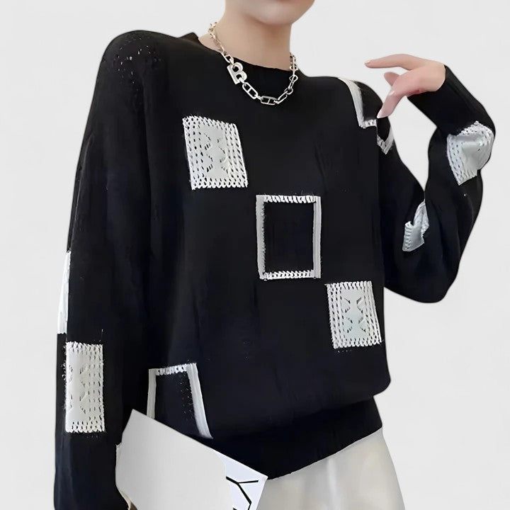 Jersey negro de manga larga con bloques geométricos blancos y detalles calados distribuidos en el pecho, las mangas y el hombro.
