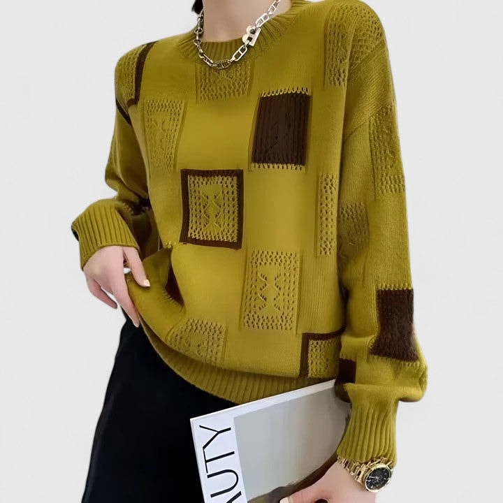 Jersey verde oliva mostrado de cerca, con diseño de bloques geométricos marrones, detalles calados y acabado acanalado en cuello, puños y bajo.