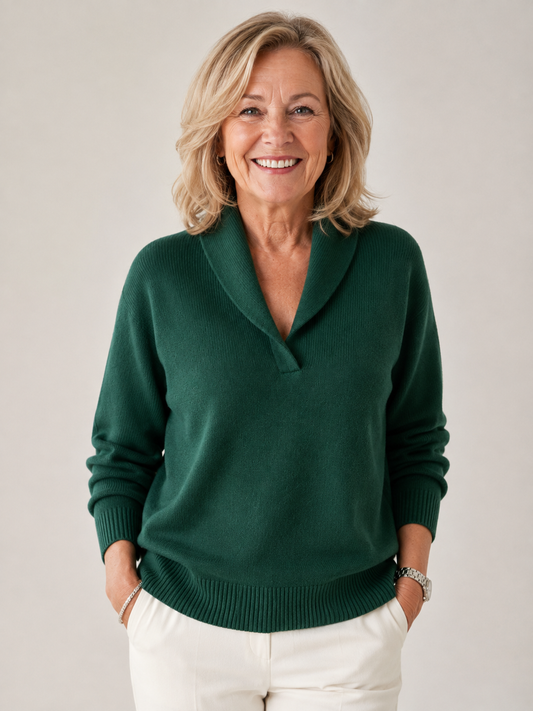 Jersey de punto verde oscuro con cuello chal y manga larga, combinado con pantalón blanco y mostrado de frente en una modelo sonriente.