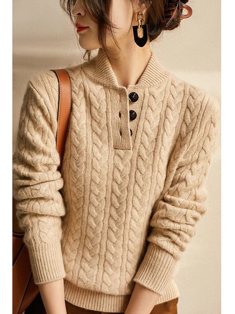 Detalle del jersey beige de cuello abotonado y relieve trenzado en el pecho y las mangas.