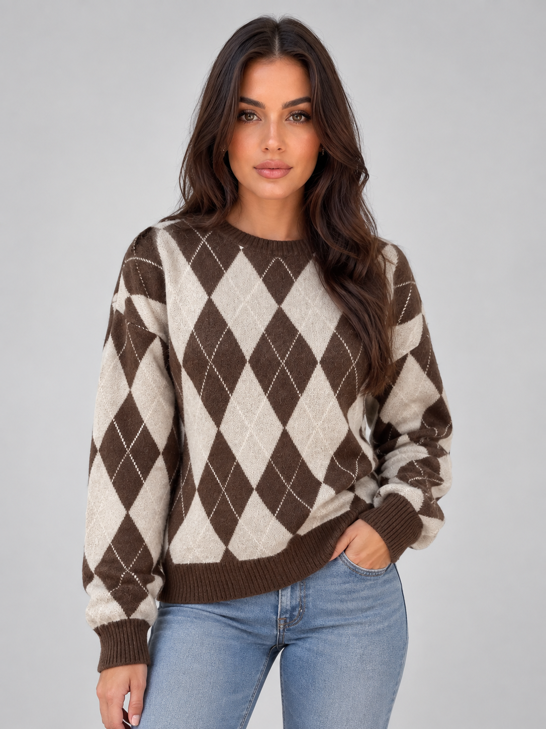 Jersey de rombos en tonos marrón y crema, con cuello redondo, mangas largas y puños acanalados, visto de frente con vaqueros.