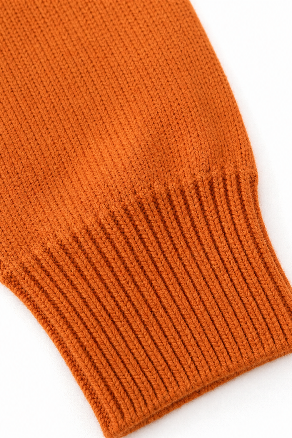 Detalle del puño naranja de manga larga con tejido acanalado.