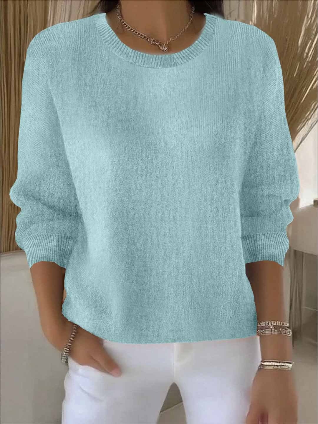 Jersey celeste de corte amplio y cuello redondo, combinado con pantalón blanco.