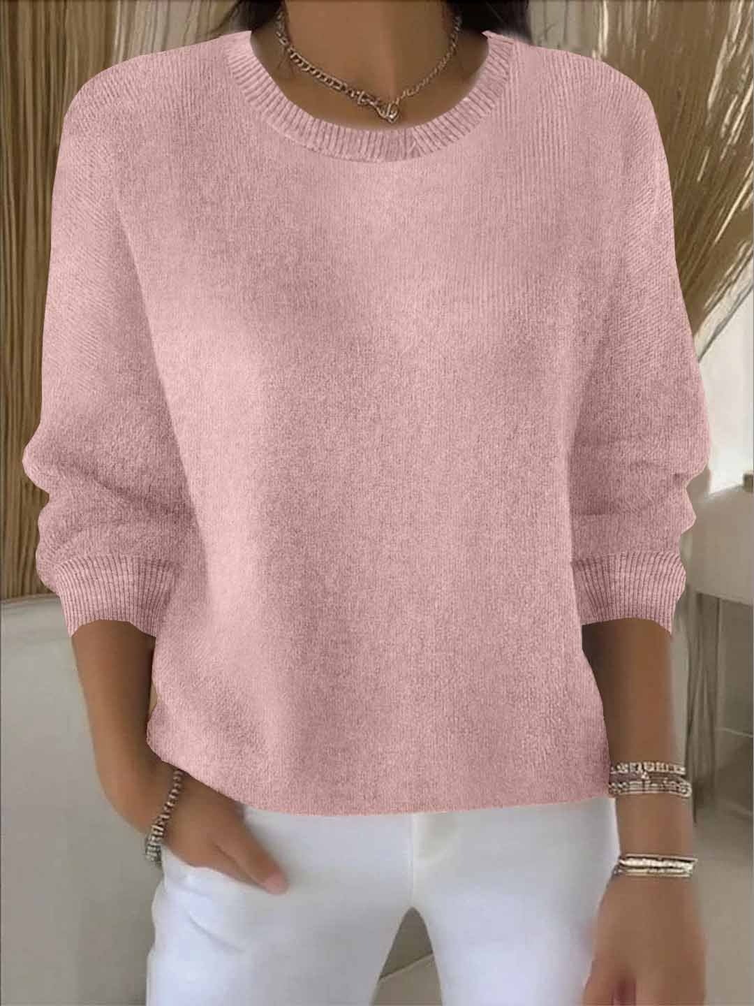 Jersey rosa claro de corte amplio, cuello redondo y mangas largas ligeramente recogidas.