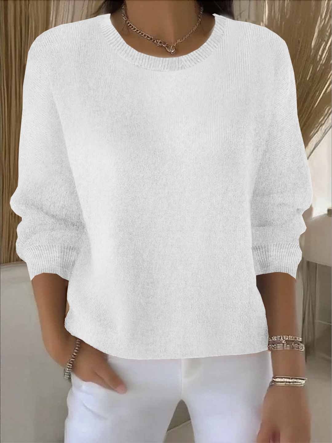 Jersey blanco holgado con cuello redondo y silueta relajada, sobre pantalón blanco.