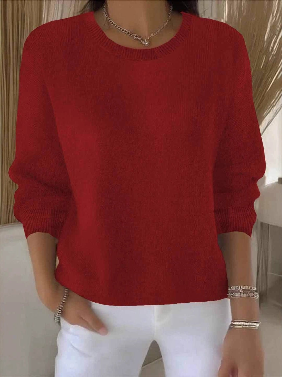Jersey rojo de silueta amplia, cuello redondo y mangas largas recogidas en los antebrazos.