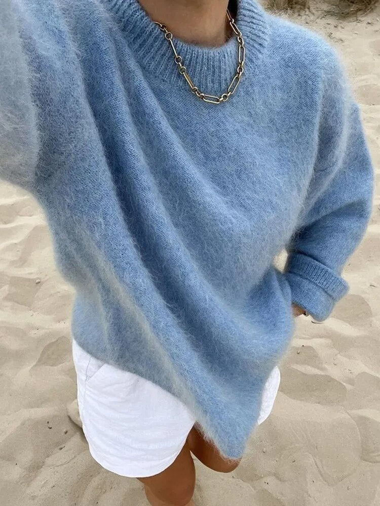 Jersey azul holgado visto desde arriba, combinado con pantalones cortos blancos y una manga remangada para mostrar el puño.
