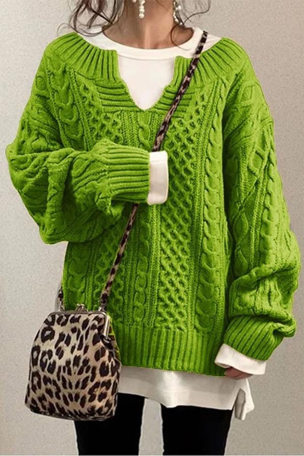 Jersey oversize verde lima con textura de trenzas, escote en V y puños acanalados pronunciados.