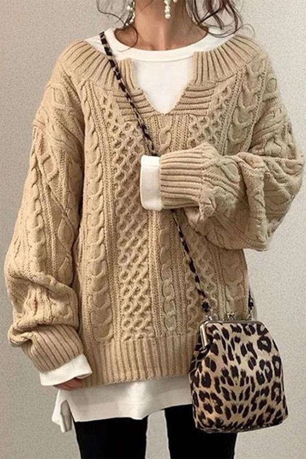 Jersey oversize beige de punto con diseño de trenzas verticales, cuello en V y bajo acanalado.