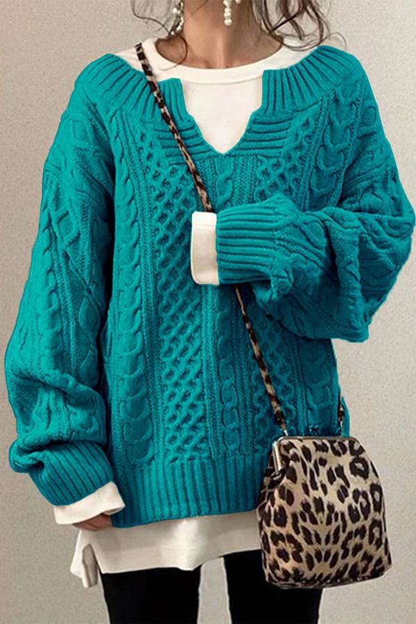 Jersey oversize turquesa de punto con trenzas marcadas, cuello en V y puños anchos.