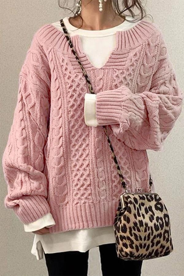 Jersey oversize rosa claro de punto trenzado con cuello en V, mangas voluminosas y ribetes acanalados.