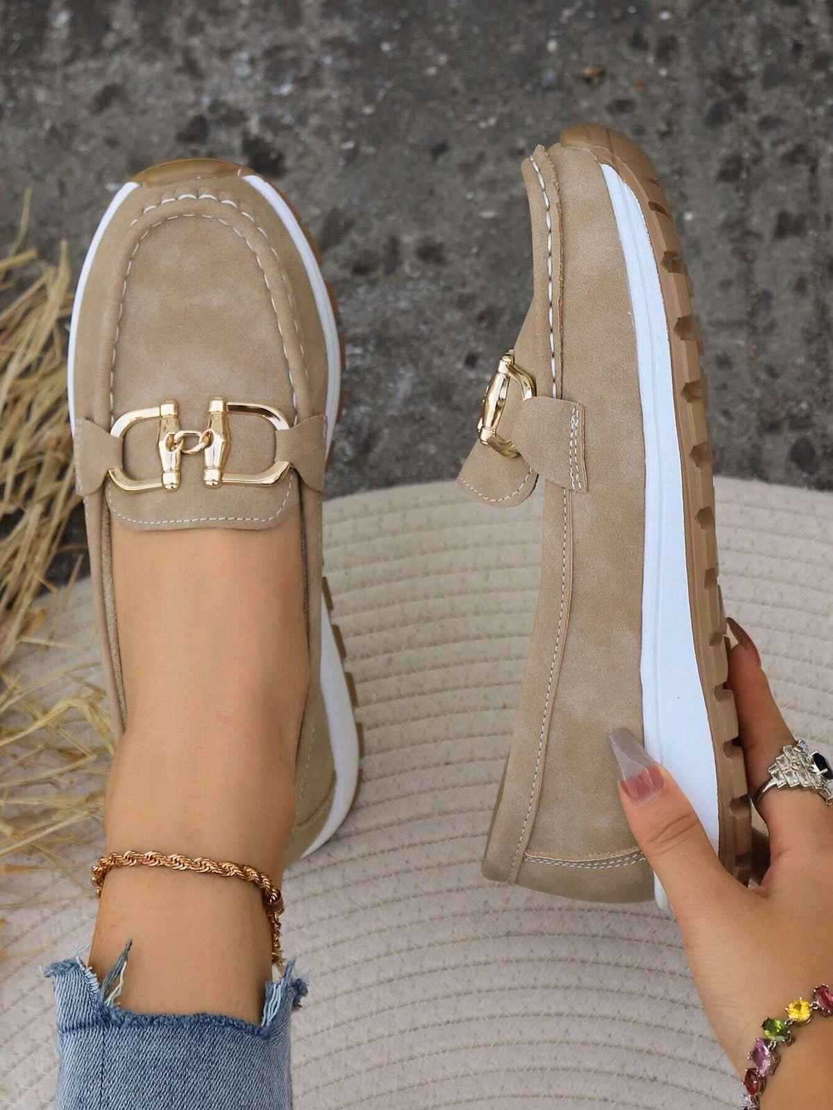 Mocasines beige presentados desde arriba y de perfil, destacando las costuras del empeine, el adorno metálico y la plataforma.
