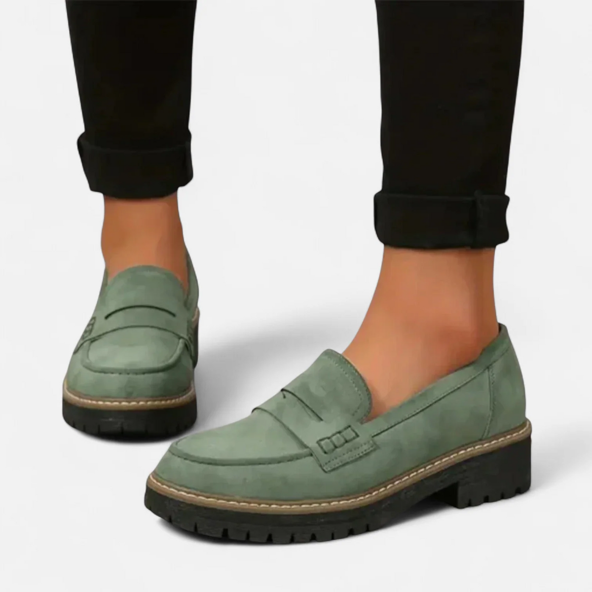 Mocasines verde salvia de mujer combinados con pantalón oscuro, mostrando el perfil bajo y la suela gruesa dentada.