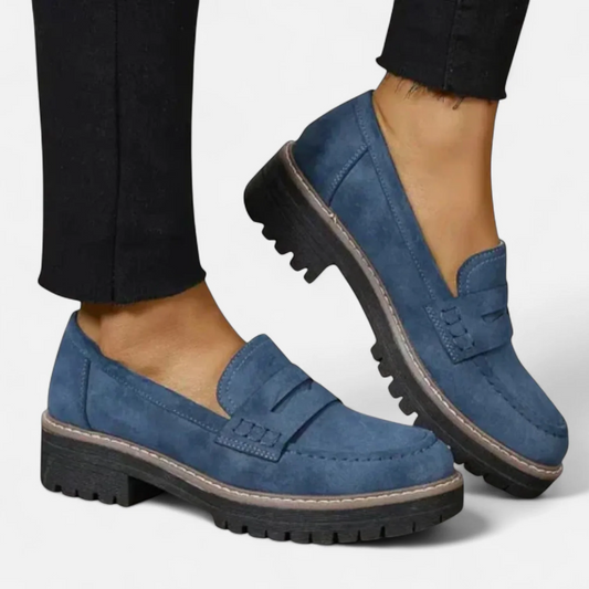 Mocasines azules de tacón bajo, con diseño sin cordones, detalle de tira sobre el empeine y suela gruesa dentada.