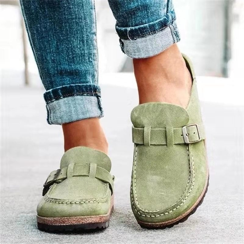 Mocasines planos en color verde claro, con diseño de mocasín cosido y cierre frontal con hebilla.
