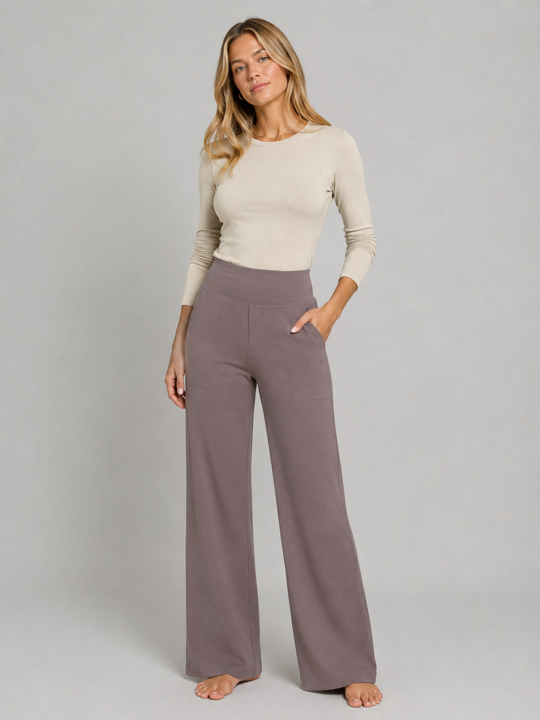 Modelo con pantalón topo de talle alto y pernera ancha, combinado con un top de manga larga y una mano dentro del bolsillo lateral.