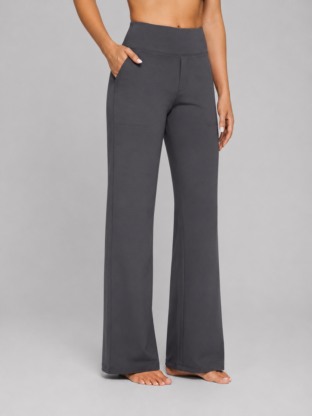 Pantalón de pernera ancha en color gris oscuro, mostrado de frente con un bolsillo lateral en uso.