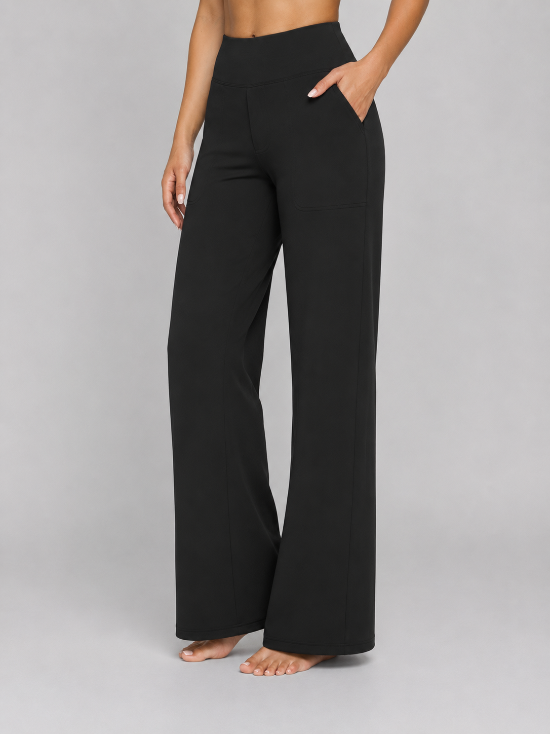 Pantalón negro de talle alto y pernera ancha, visto de frente con una mano en el bolsillo lateral.