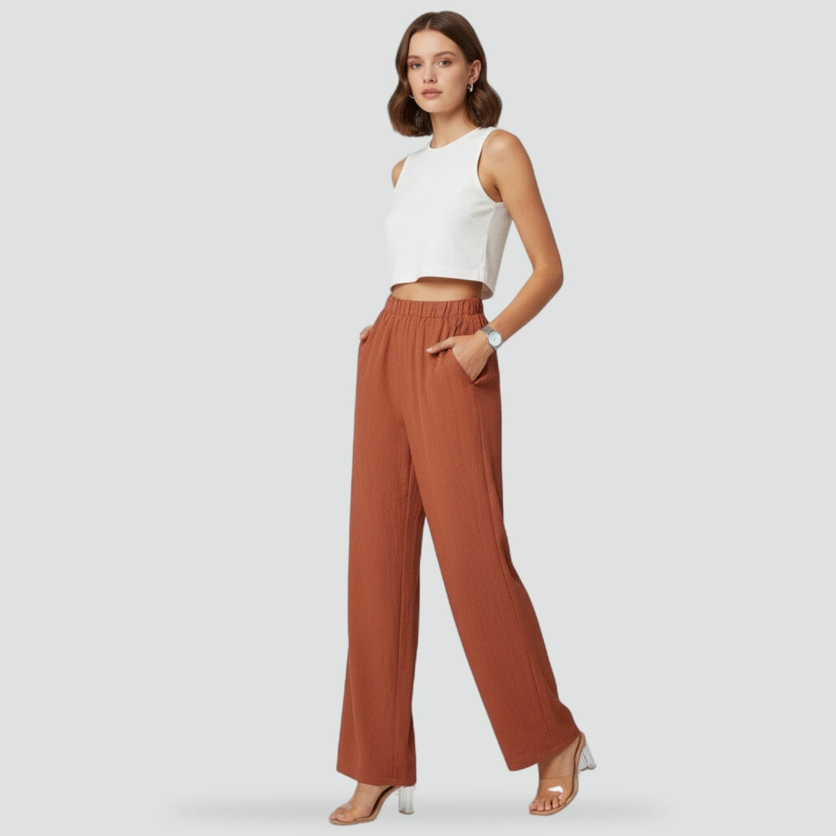 Vista frontal completa del pantalón terracota de cintura alta y pierna recta, combinado con un top blanco y sandalias de tacón.