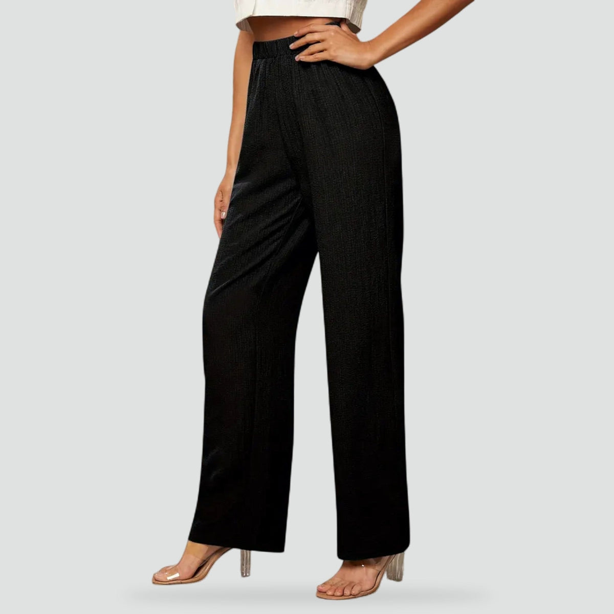 Pantalón negro de tiro alto con cintura elástica, bolsillos laterales y piernas rectas, mostrado de frente.