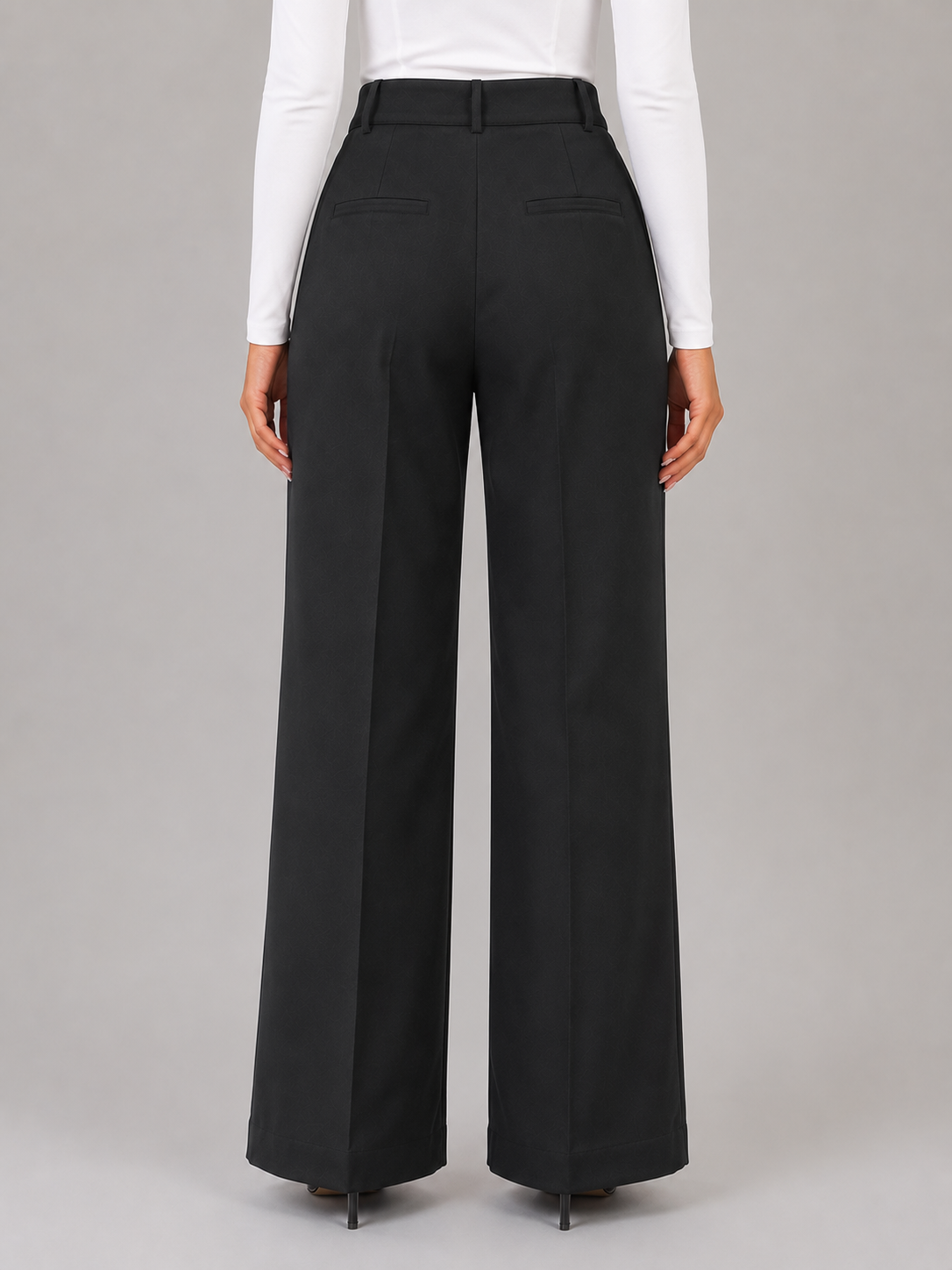 Vista posterior de un pantalón negro de talle alto y pierna ancha, con trabillas y bolsillos traseros discretos.