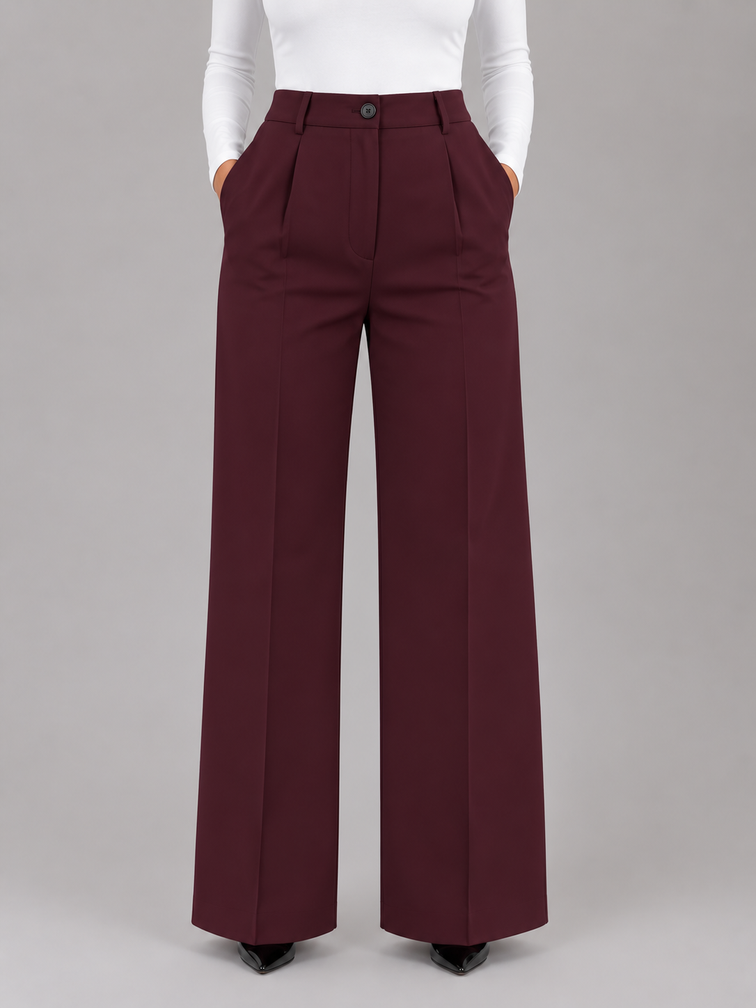 Pantalón de vestir burdeos de talle alto y pierna ancha, visto de frente, con pinzas delanteras, botón y bolsillos laterales.