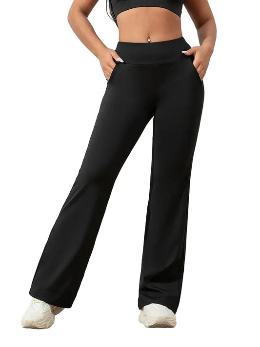 Pantalón deportivo negro de tiro alto y pierna ancha, mostrado de frente con bolsillos laterales y zapatillas blancas.