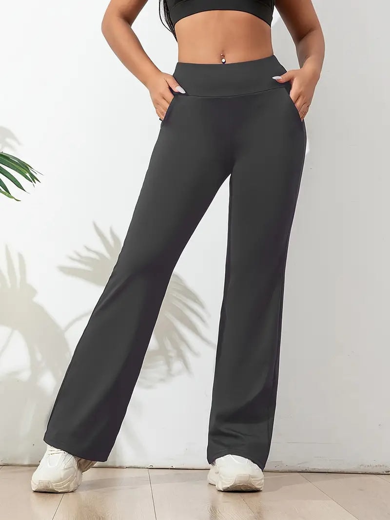 Pantalón deportivo gris oscuro de cintura alta y corte amplio, presentado de frente en un espacio interior iluminado.
