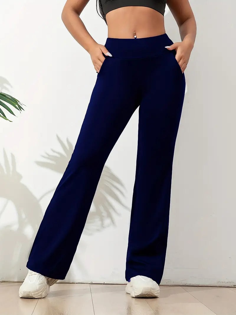 Pantalón deportivo azul marino con tiro alto y piernas anchas, combinado con un top corto negro y zapatillas blancas.