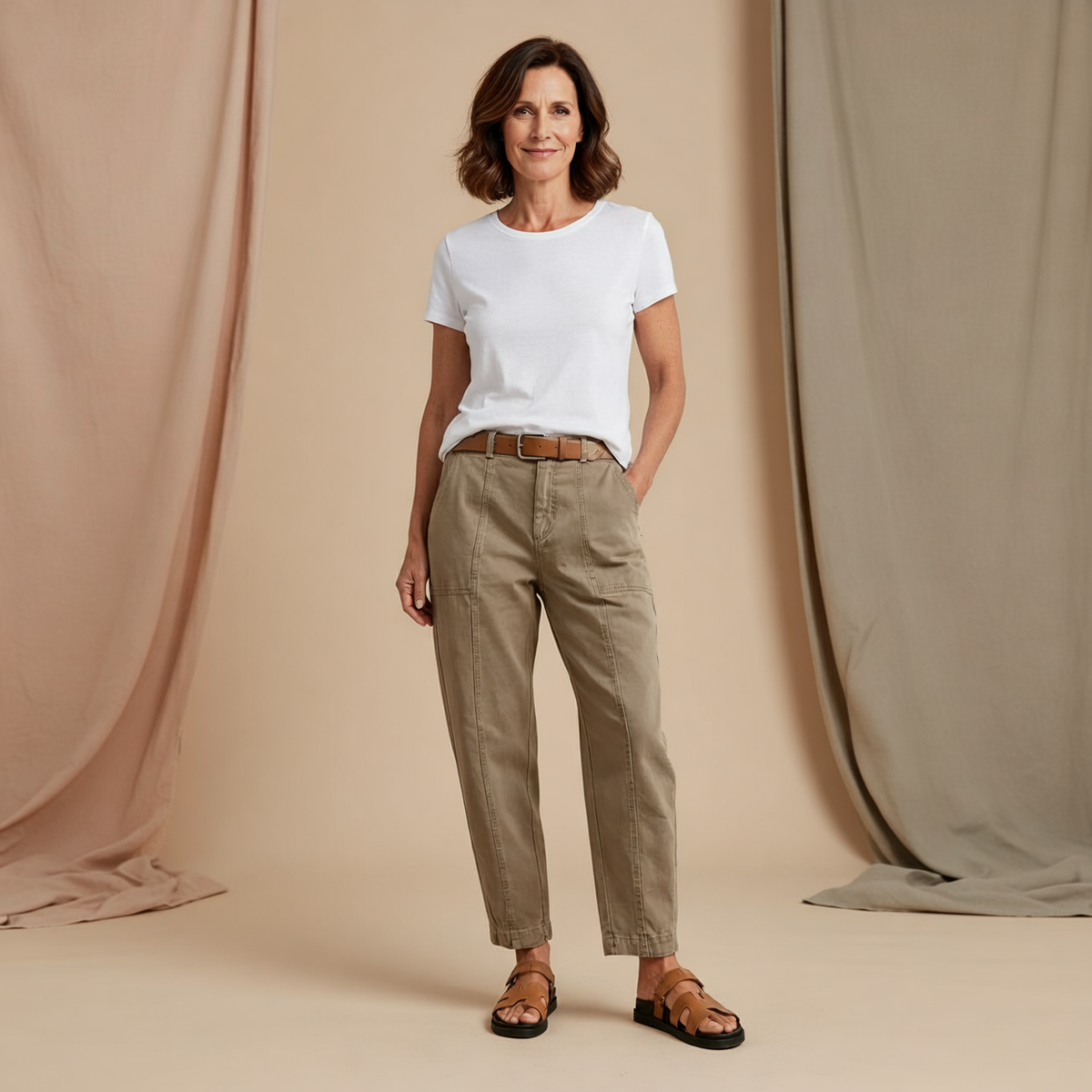 Pantalón utility de tiro alto y pernera cónica en tono beige, mostrado de frente con bolsillos laterales y cinturón marrón.