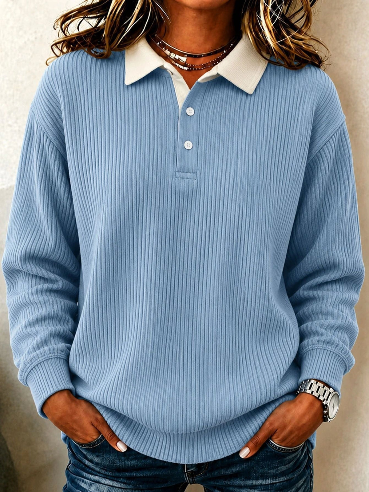 Polo azul claro de corte relajado con cuello en contraste, tapeta corta y textura de canalé vertical.