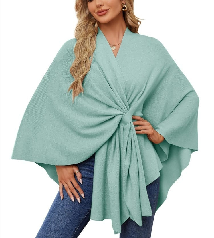 Poncho tipo chal verde menta con nudo frontal y pliegues reunidos en el centro.