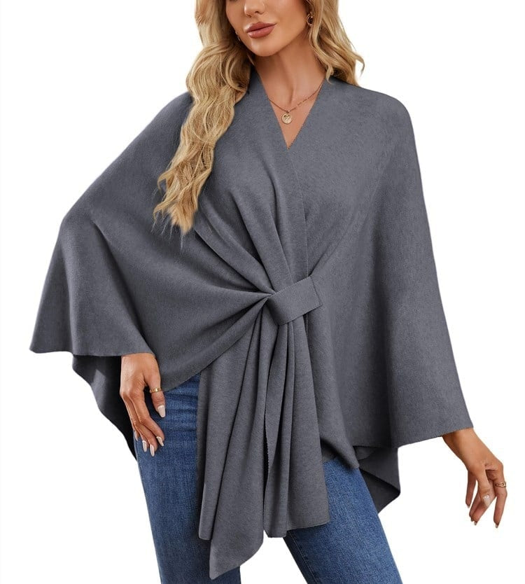 Poncho tipo chal gris antracita con banda central visible, mangas amplias y caída asimétrica.