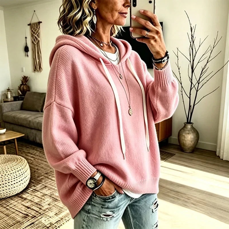 Sudadera rosa con capucha y cordones, vista de perfil en un autorretrato y combinada con vaqueros claros.