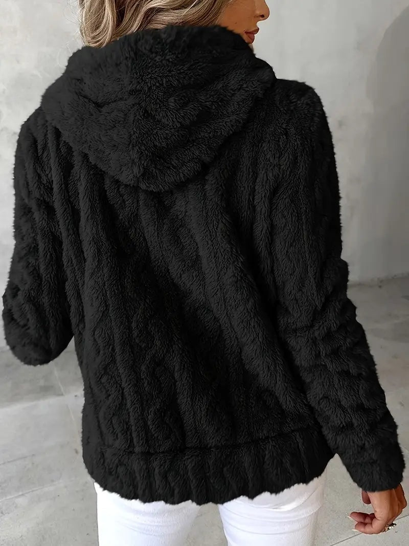 Sudadera negra vista por detrás, con capucha amplia, mangas largas y bajo texturizado.