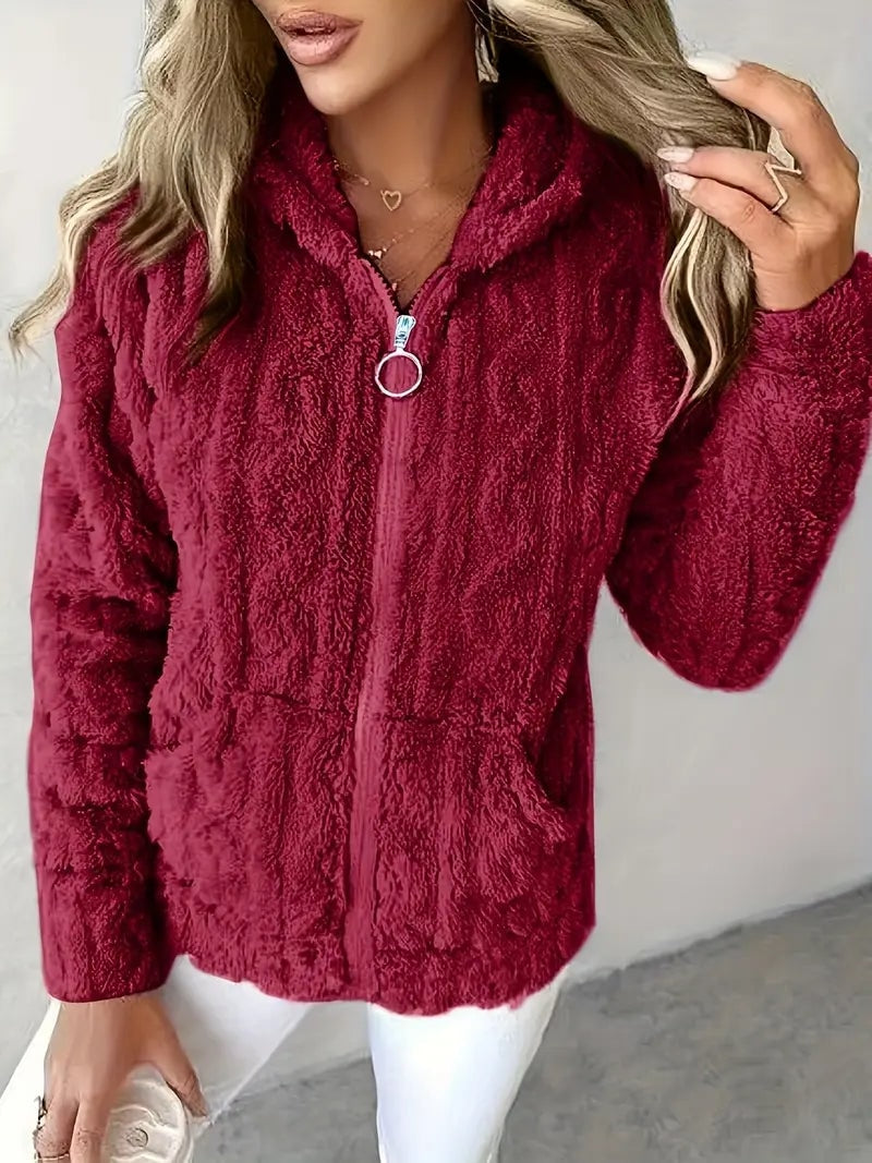 Sudadera con capucha burdeos de textura suave, mostrada de frente con cremallera y bolsillos delanteros.