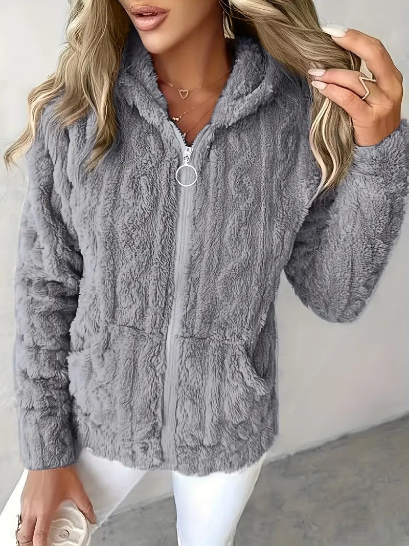 Sudadera con capucha gris de textura envolvente, mangas largas, cremallera frontal y bolsillos bajos.
