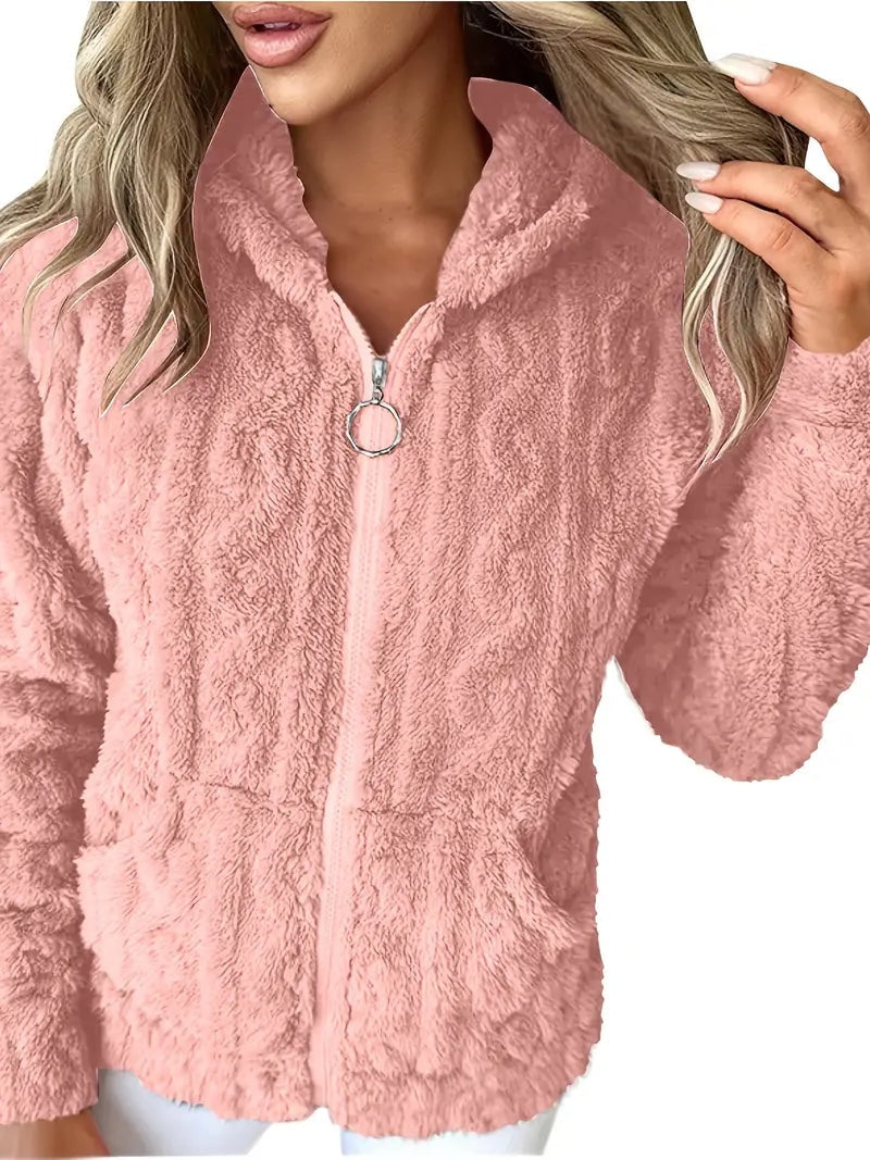 Vista frontal cercana de la sudadera rosa con la capucha abierta, textura mullida y cremallera parcialmente subida.