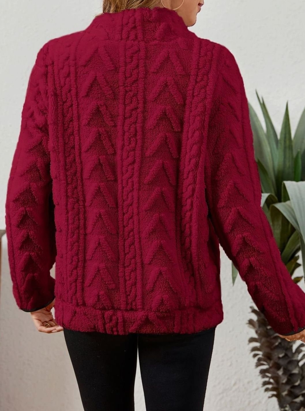 Vista posterior de la sudadera burdeos, con cuello alto, mangas largas y paneles verticales en relieve.