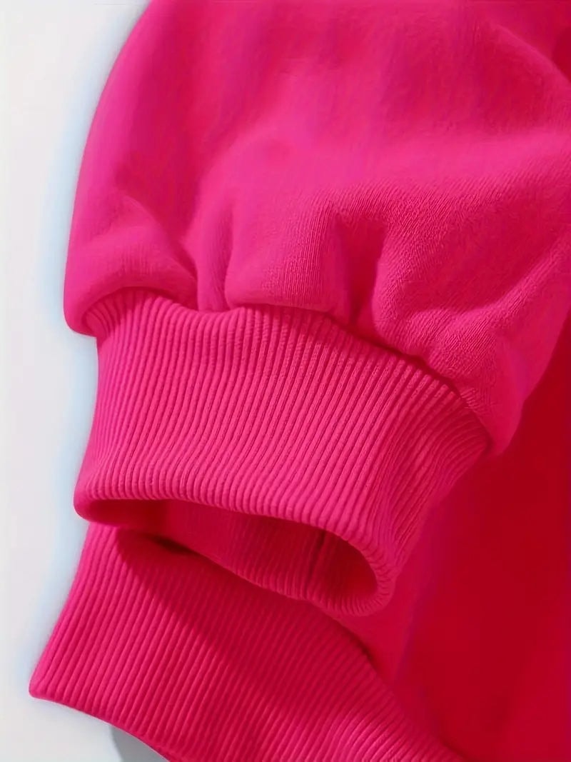 Detalle del puño de canalé y la terminación de la manga larga de la sudadera fucsia.